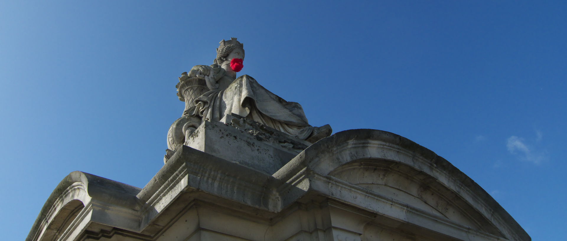 Photo d'une statue portant une barbe rouge, Paris, place de la Concorde.