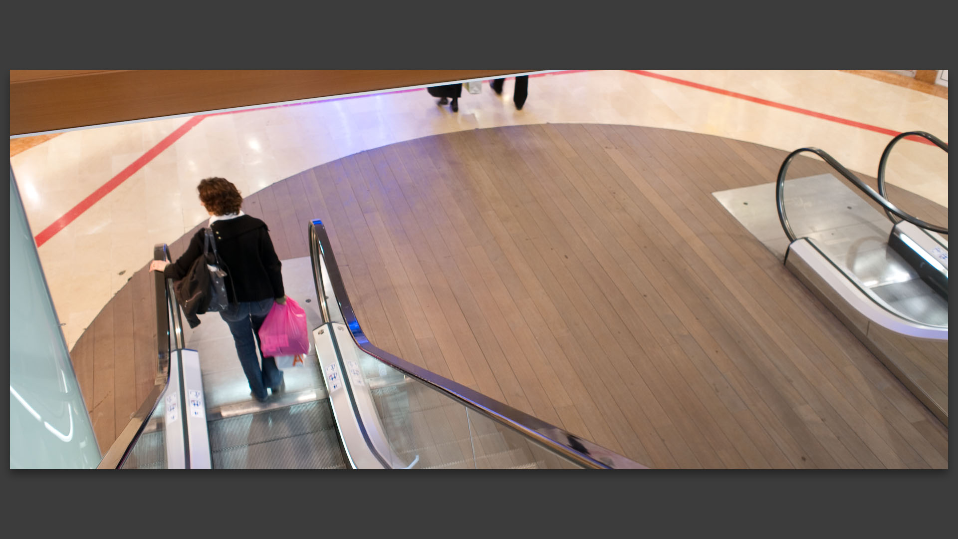 Femme sur un escalator, au centre commercial des Tanneurs, à Lille.