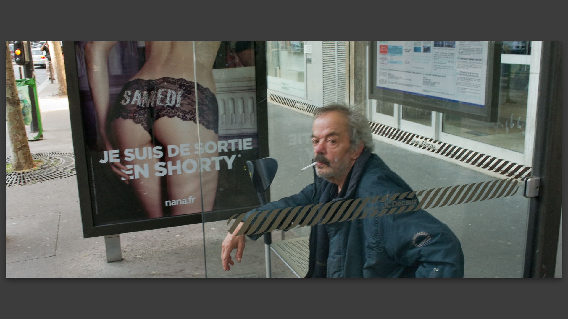 Mendiant assis à un arrêt d'200bus, av. de Saint-Ouen, à Paris.