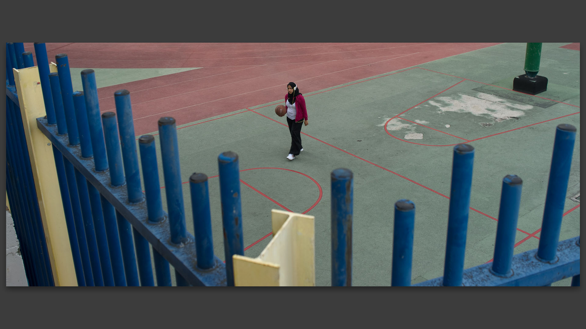 Jeune fille voilée jouant au basket sur le terrain de sport du quartier Beaugrenelle, à Paris.
