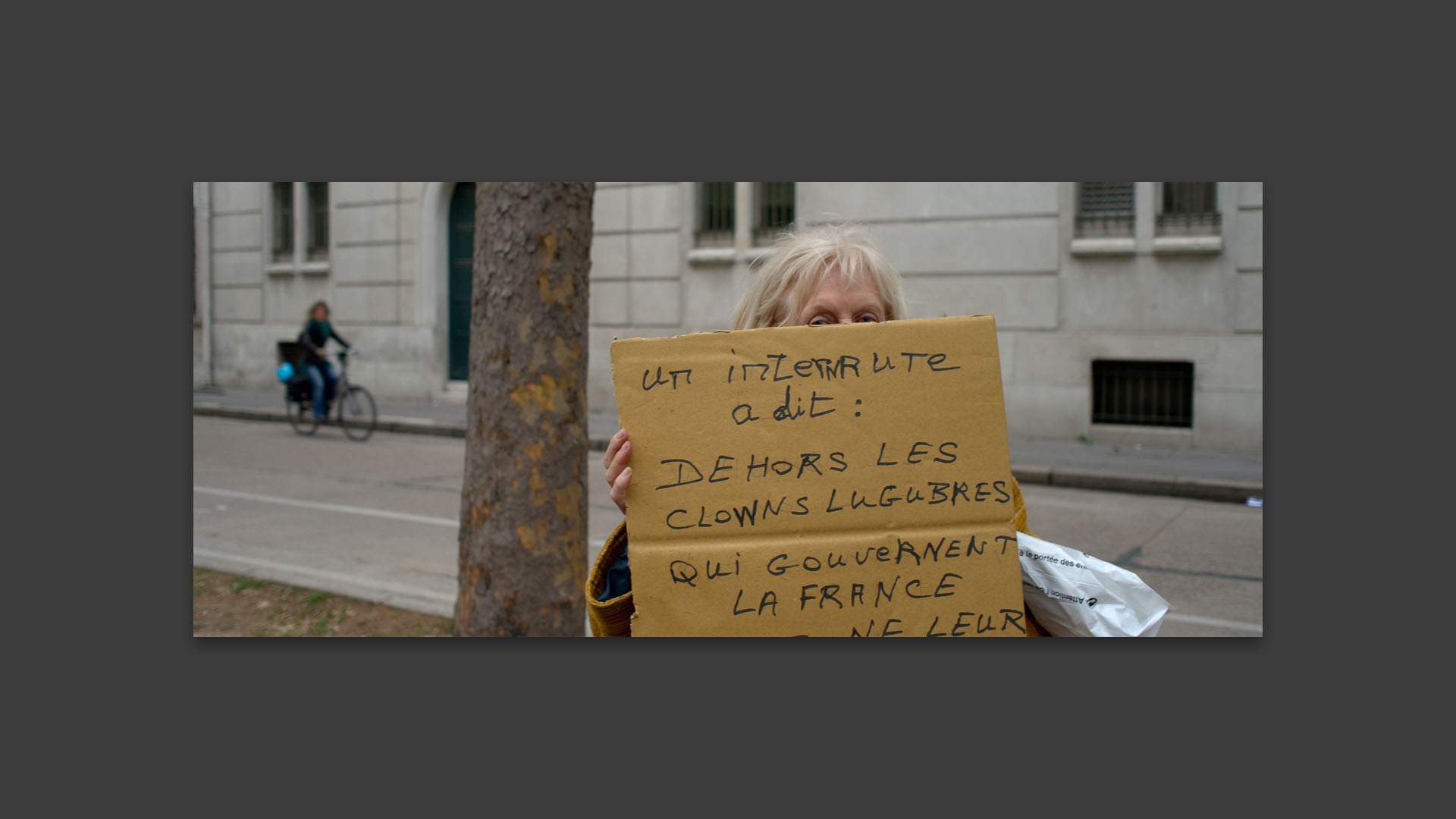 Vieille dame portant un écriteau dans la manifestation contre la réforme des retraites, boulevard des Invalides, à Paris.