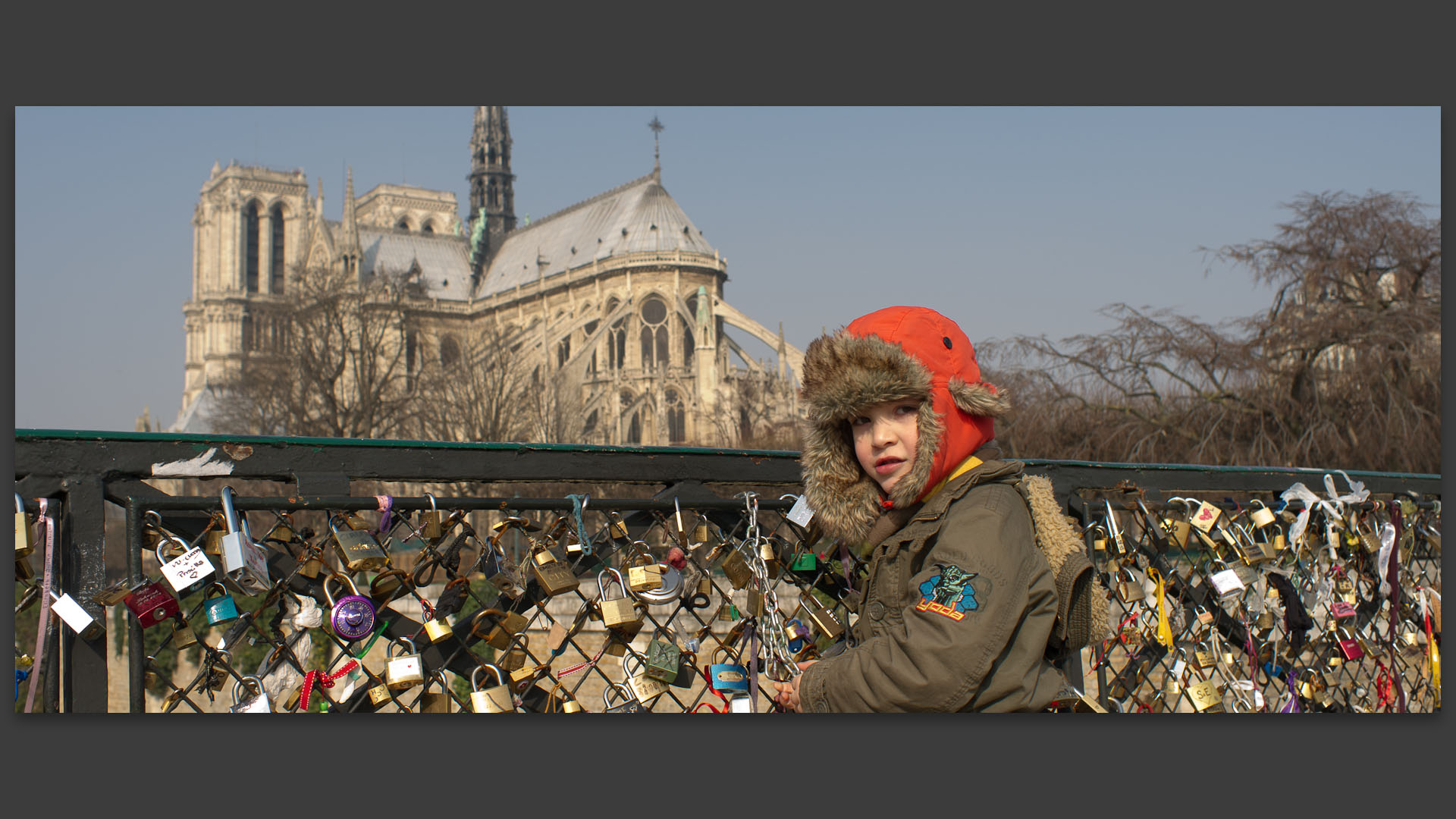 Enfant jouant avec les cadenas du pont de l'Archevêché, à Paris.