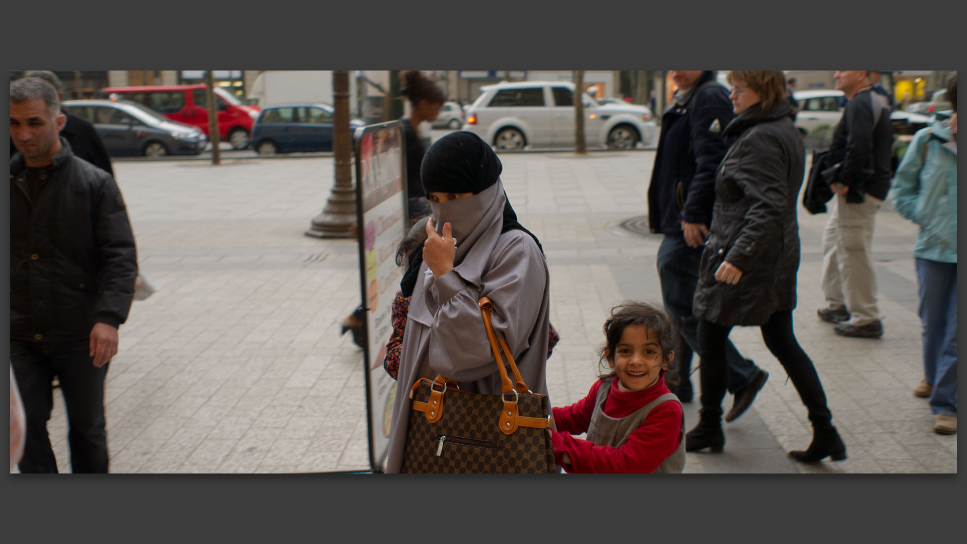 Femme intégralement voilée avec sa fille, avenue des Champs Elysées, à Paris.