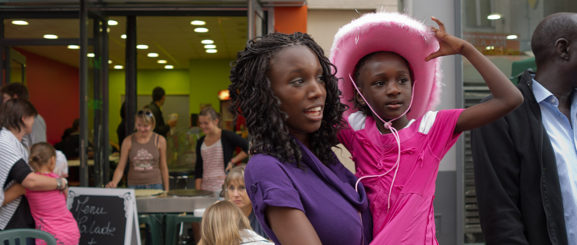 Jeune fille avec un chapeau coloré à la braderie, rue Gambetta, à Lille.