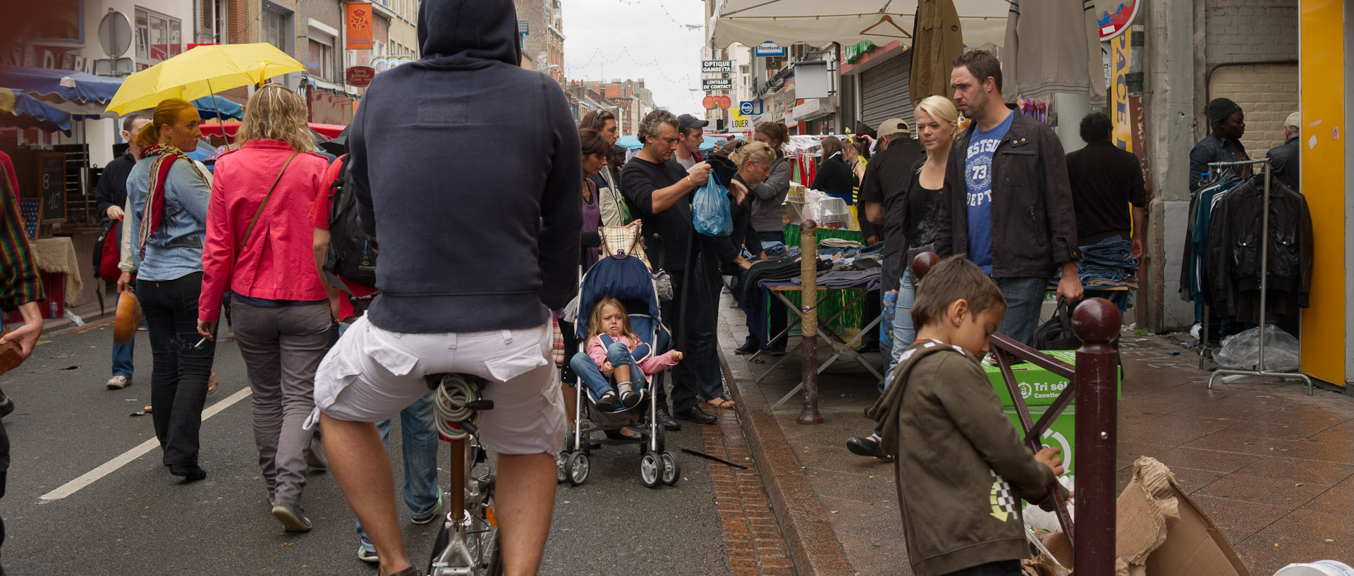 Cycliste et passants à la braderie, rue Gambetta, à Wazemmes, Lille.