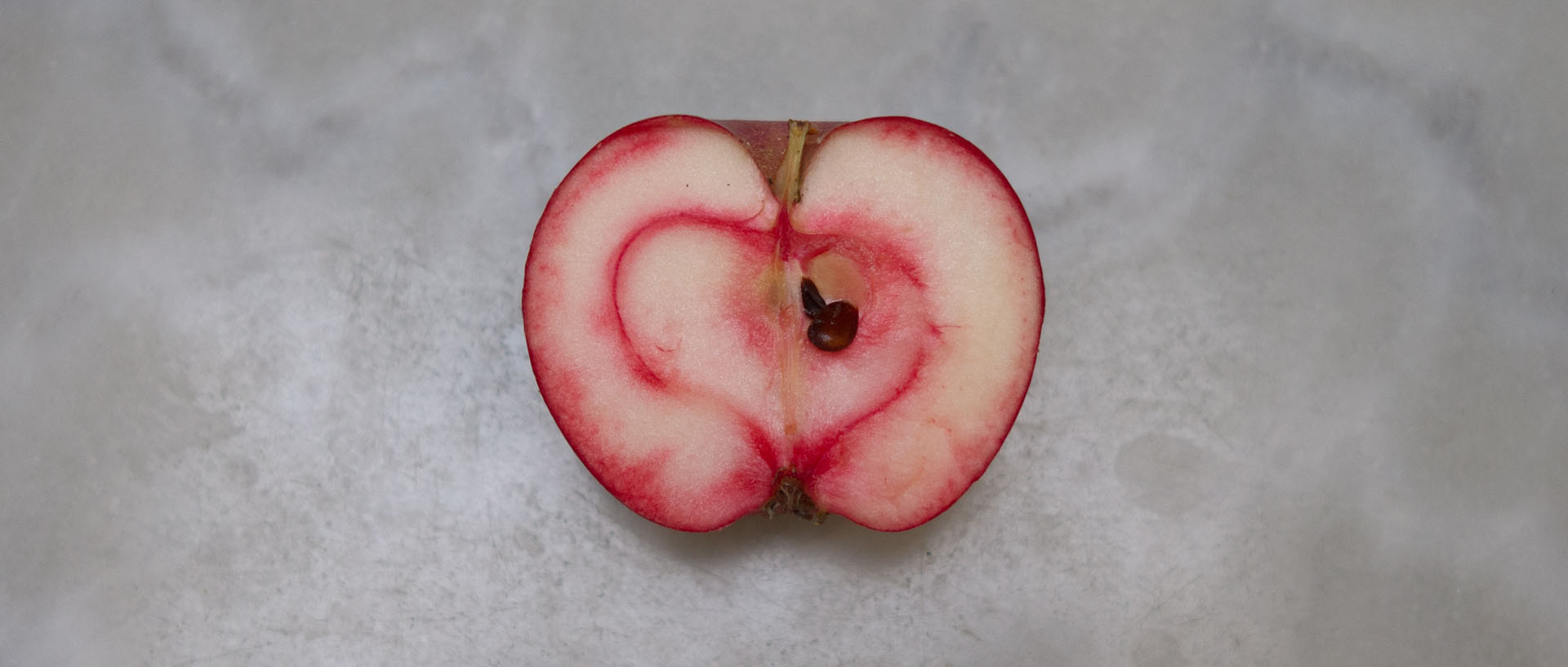 Pomme rouge sur marbre blanc, à Croix.