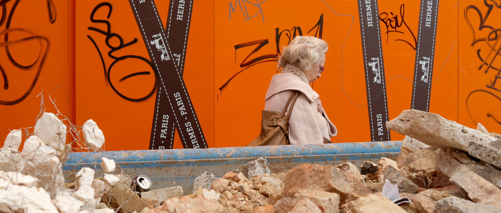 Femme passant derrière une benne de gravats, rue de la Grande Chaussée, à Lille.