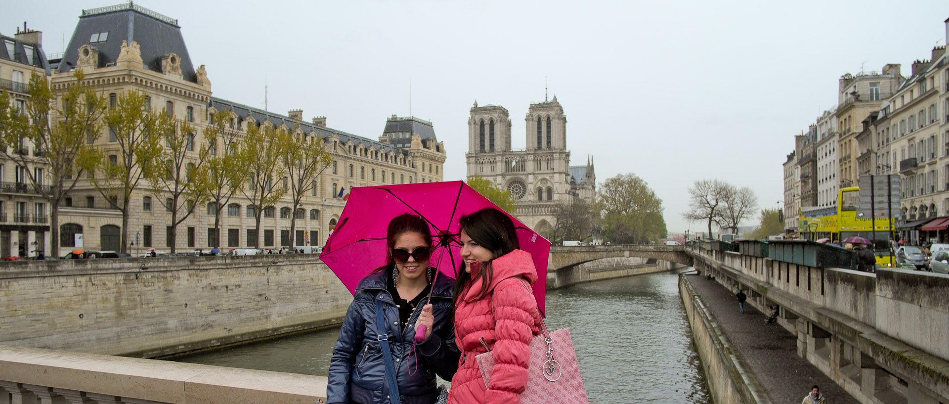 Touristes sous un parapluie, sur le pont Saint-Michel, à Paris.