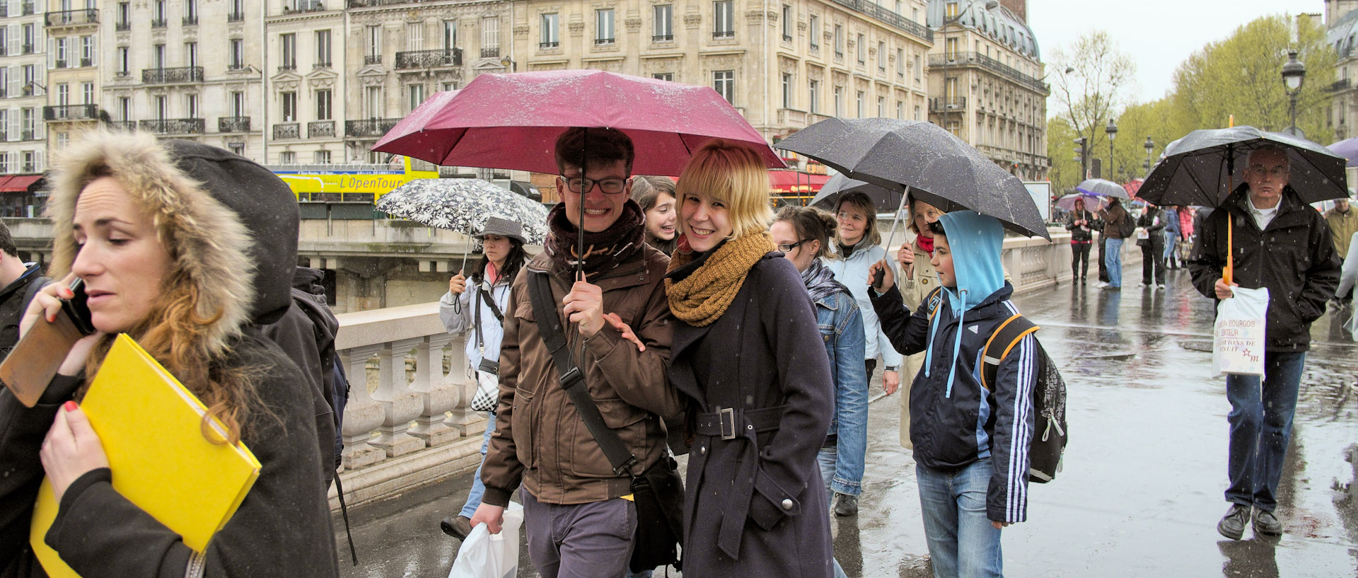 Touristes sous des parapluies, sur le pont Saint-Michel, à Paris.