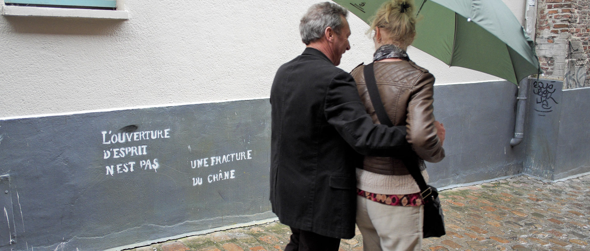Couple devant un mur tagué, Cours à l'Eau, à Lille.