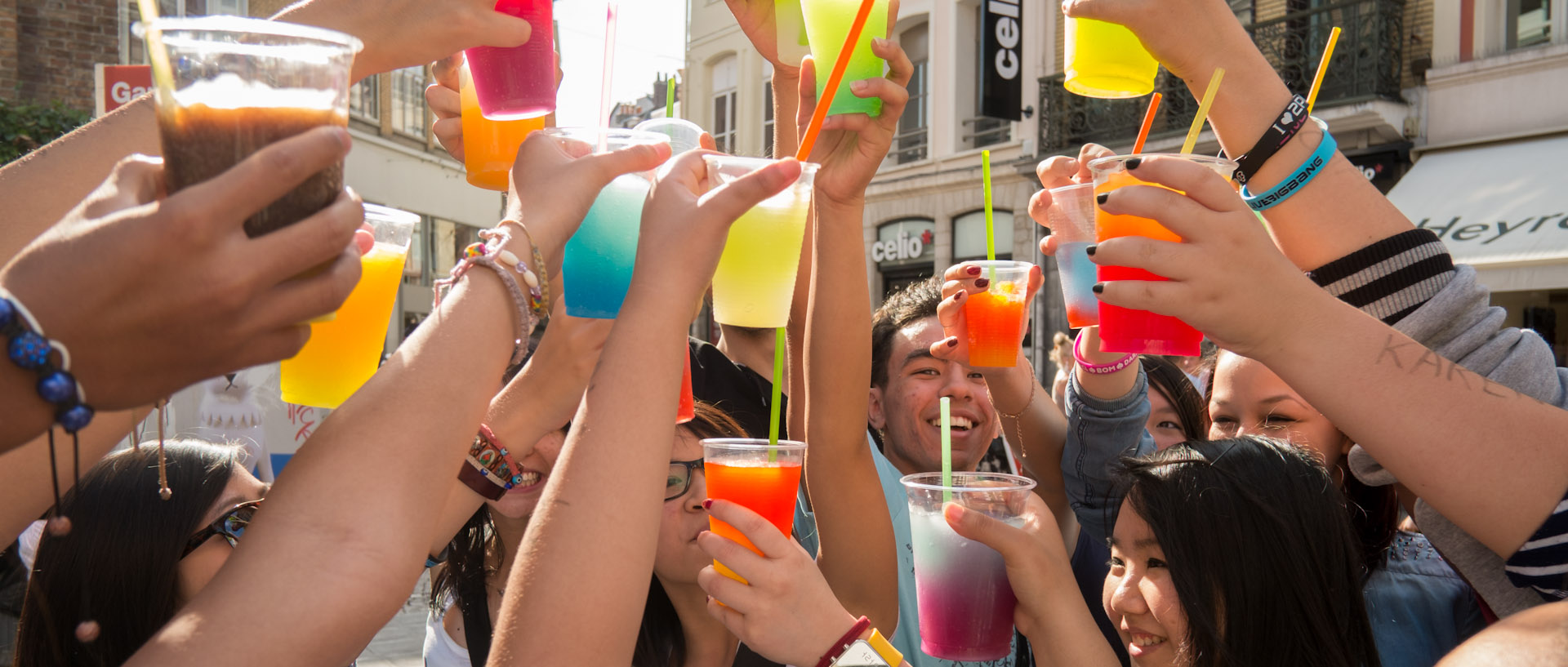 Jeunes levant leurs verres multicolores, rue de Béthune, à Lille.