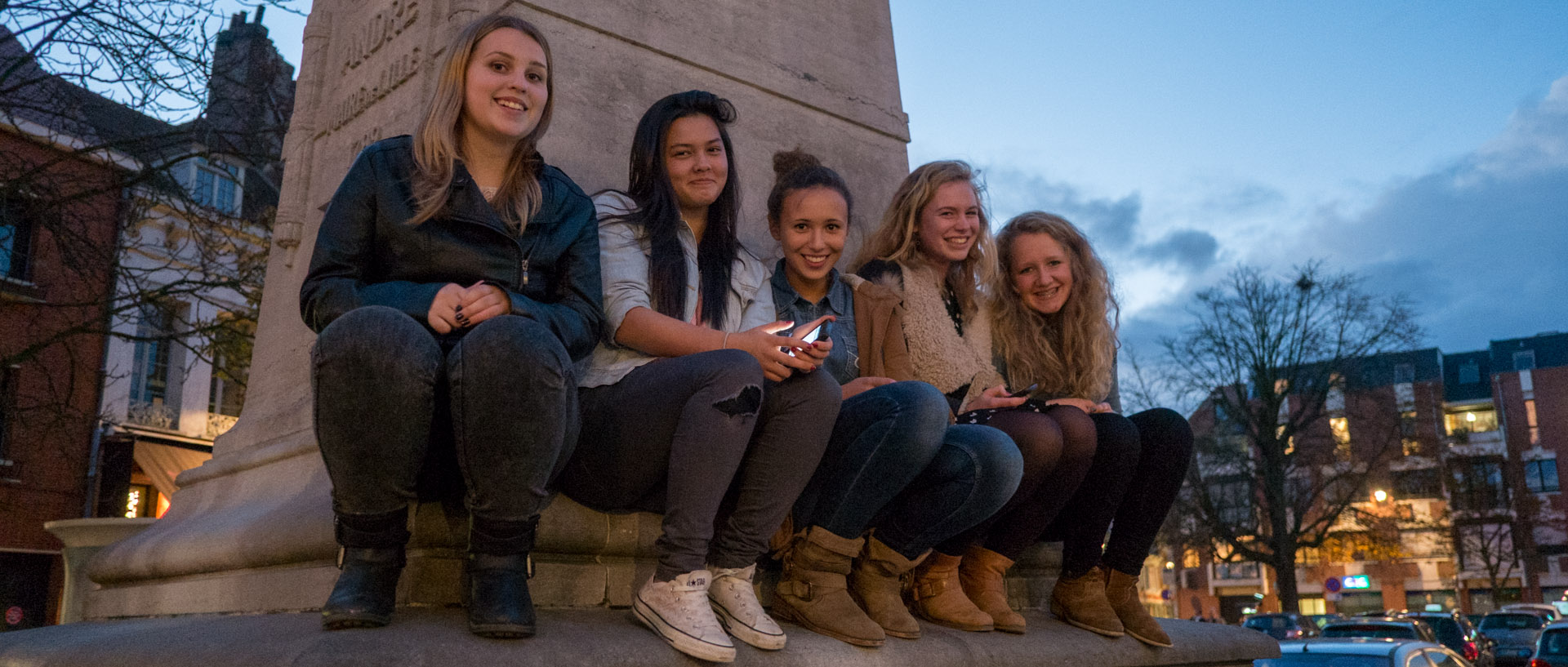 Jeunes filles assises sur le socle de la statue de François André-Bonte, ancien maire de Lille, place du Concert, à Lille.