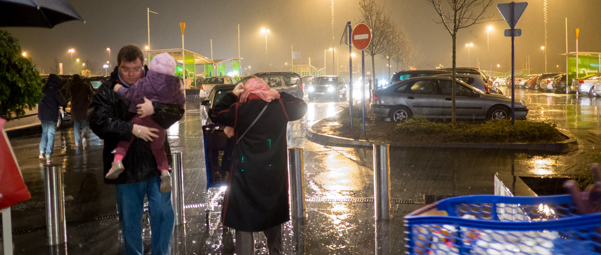 Un père et son enfant sous une averse, dans le parking du centre commercial Carrefour, à Wasquehal.