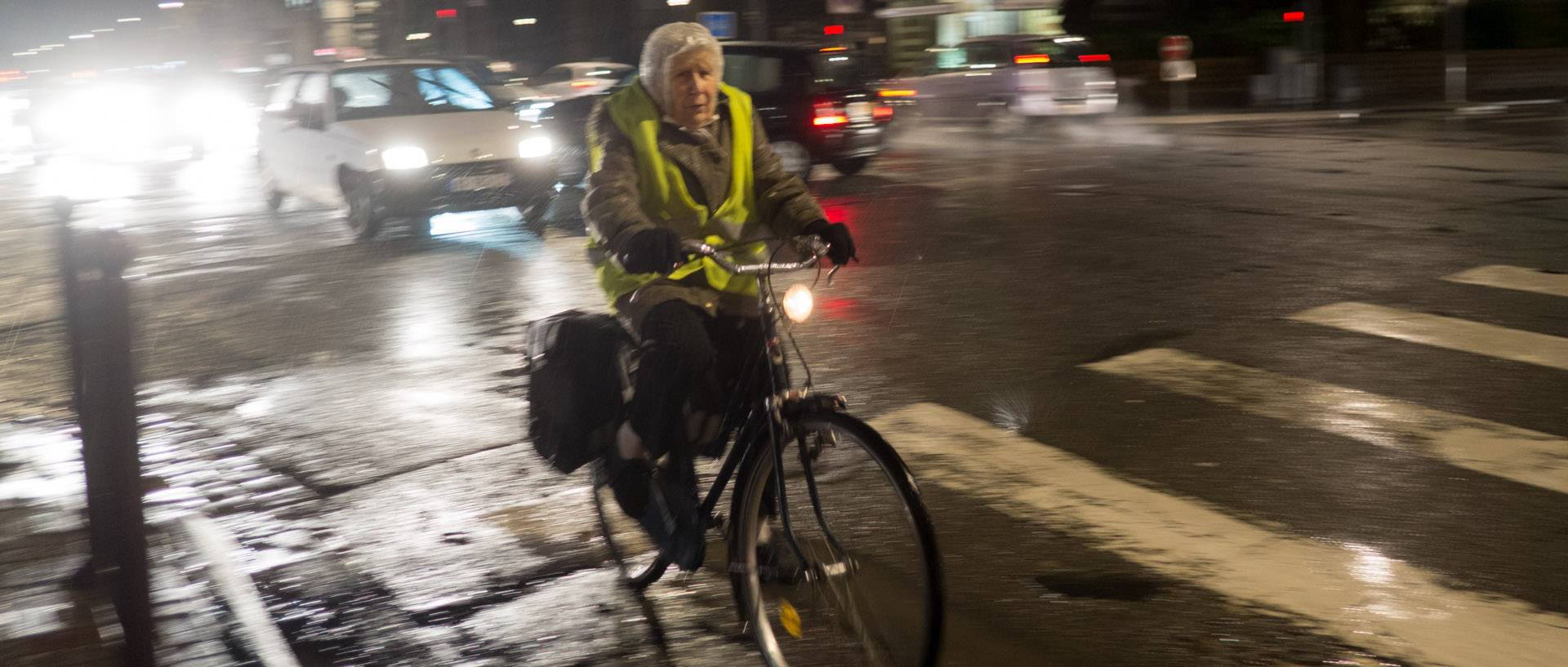 Vieille dame sur un vélo, sous la pluie, boulevard Vauban, à Lille.