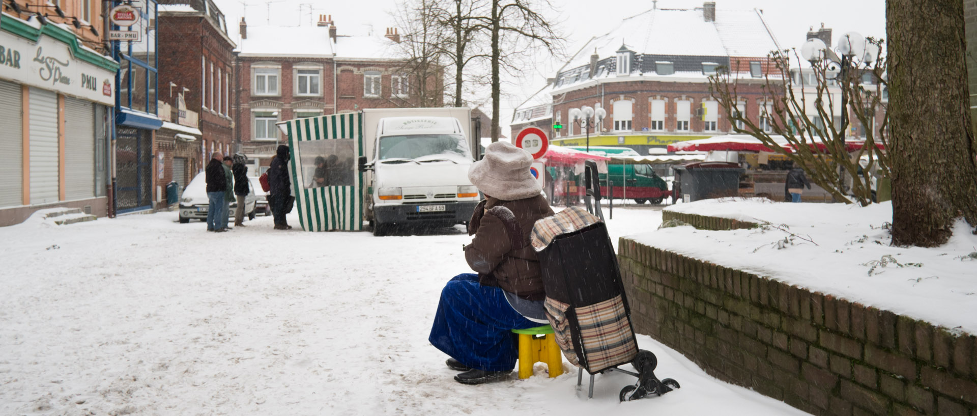 Mendiante sous la neige, dans le marché Saint-Pierre, place de la Liberté, à Croix.