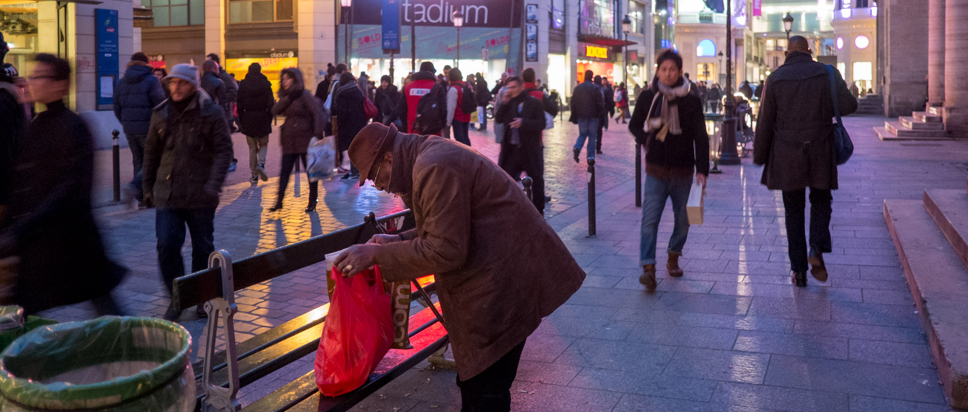 Vieil homme fouillant dans un sac, rue Caumartin, à Paris.