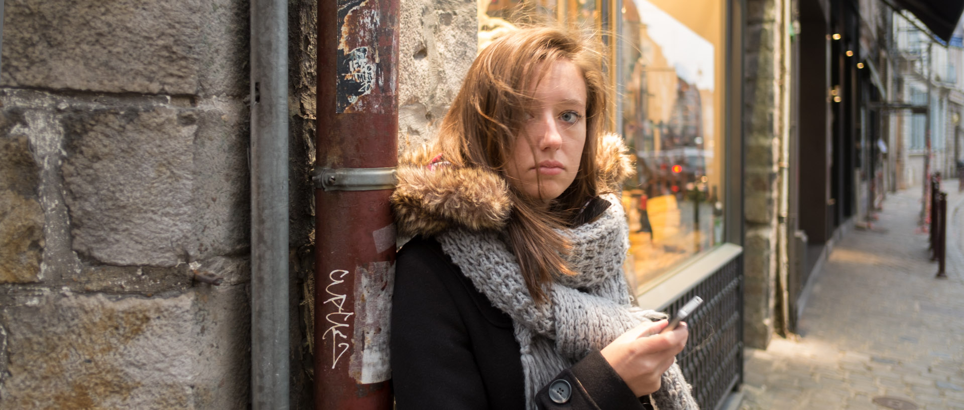 Jeune fille avec son téléphone portable, rue Basse, à Lille.