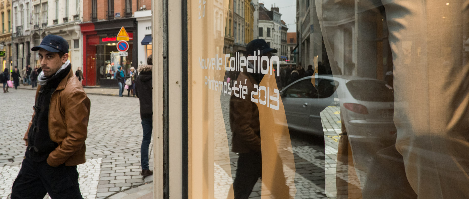 Jeune homme devant une boutique de mode, rue Basse, à Lille.