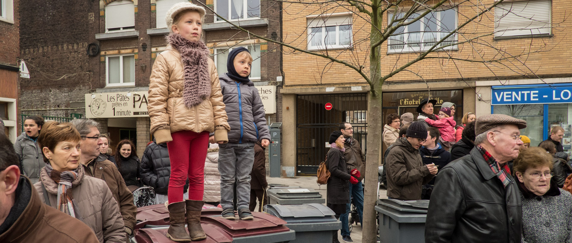 Enfants sur des poubelles regardant le défilé des géants, du week-end Geant, à Tourcoing.