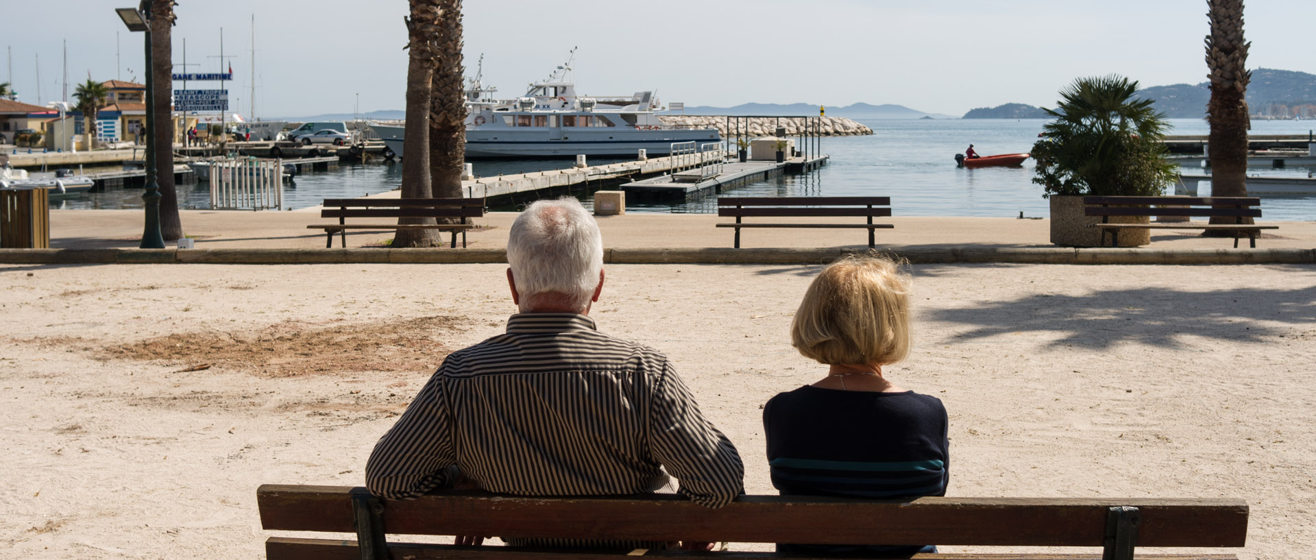 Couple sur un banc devant le port du Lavandou.