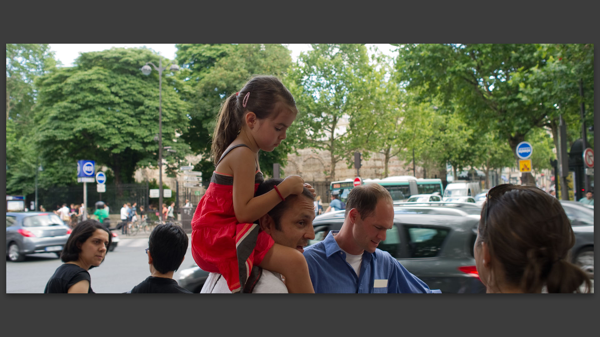 Fillette sur les épaules de son père, boulevard Saint-Germain, à Paris.