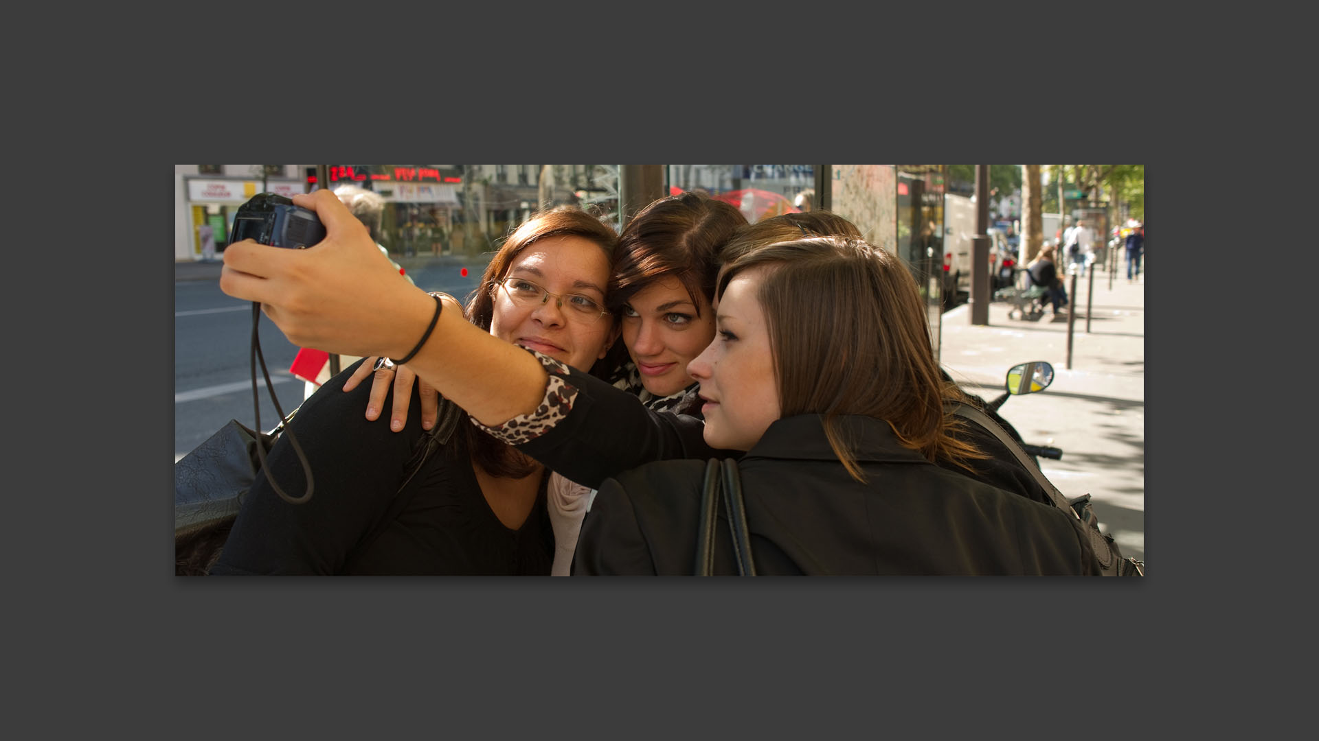 Jeunes filles en train de se photographier, boulevard du Montparnasse, à Paris.