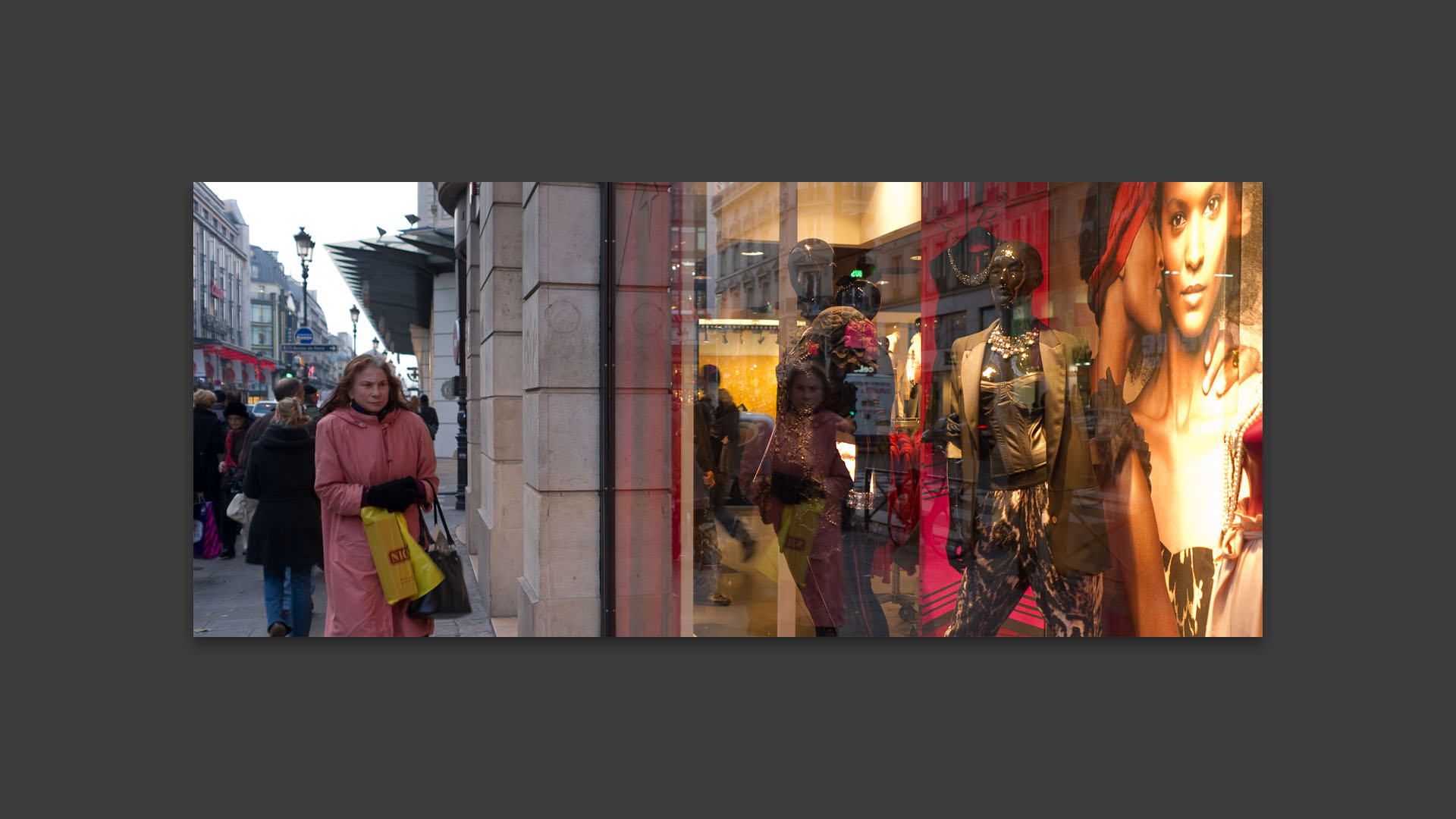 Femme transie passant devant un magasin, rue de Rivoli, à Paris.