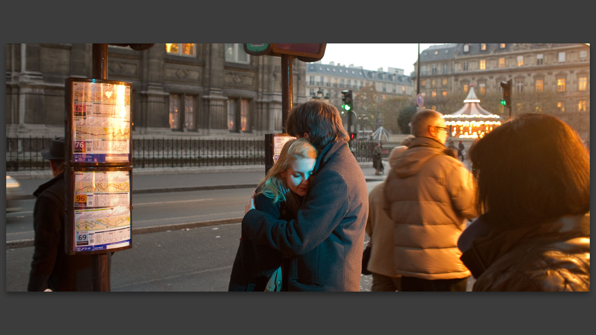 Jeune couple d'amoureux attendant l'autobus, rue de Rivoli, à Paris.