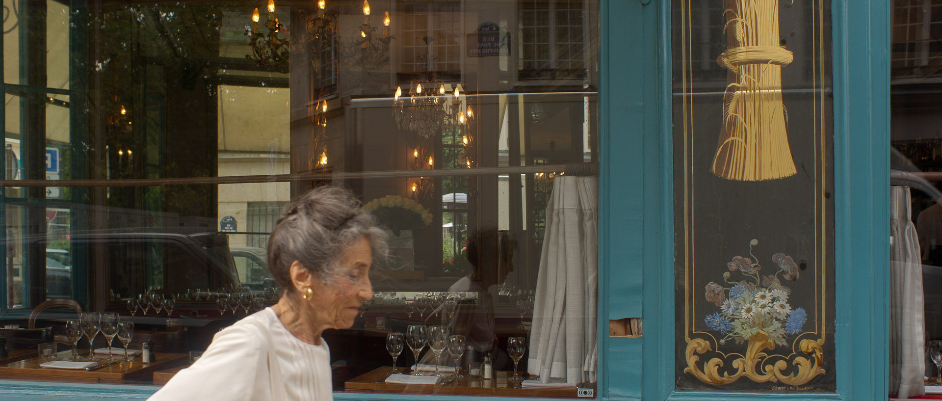 Passante devant la vitrine du restaurant chez Julien, rue du Pont Louis-Philippe, à Paris.