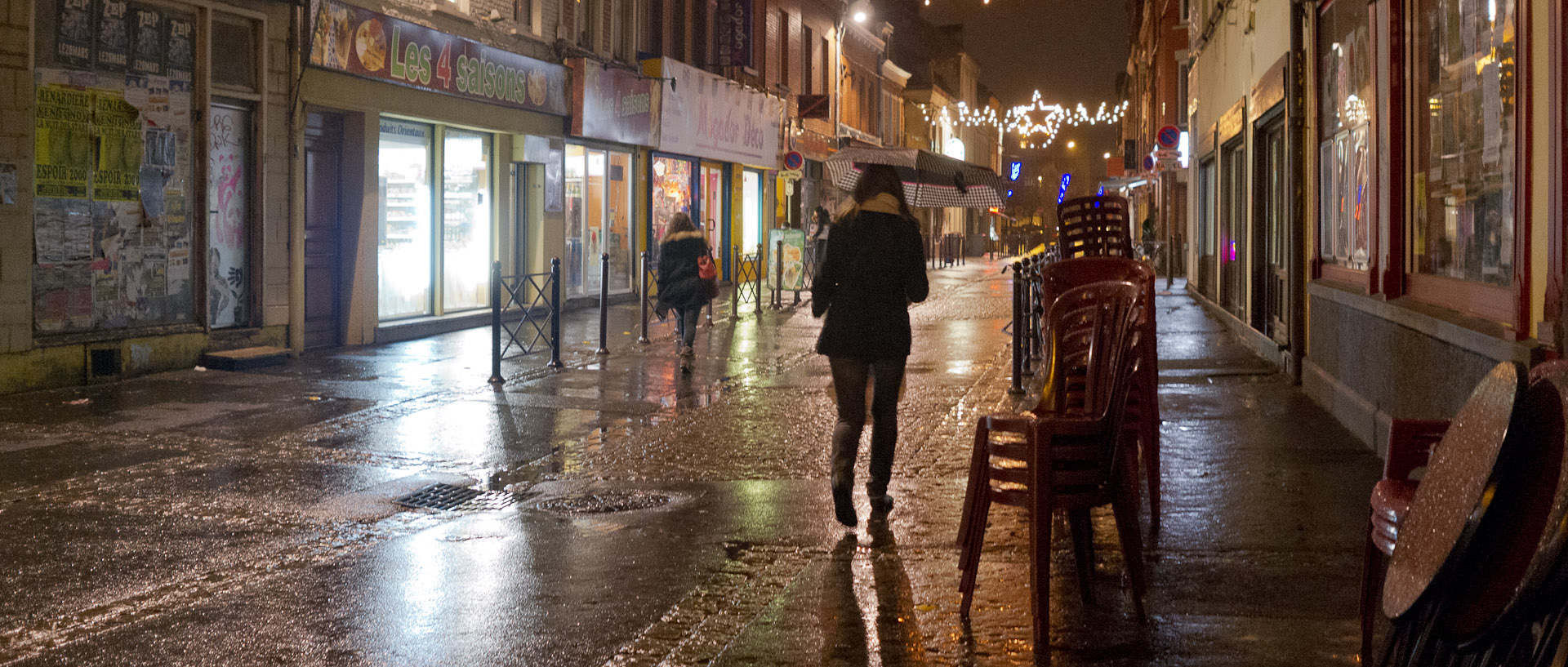 Femme avec un parapluie, rue des Sarrazins, à Wazemmes, Lille.