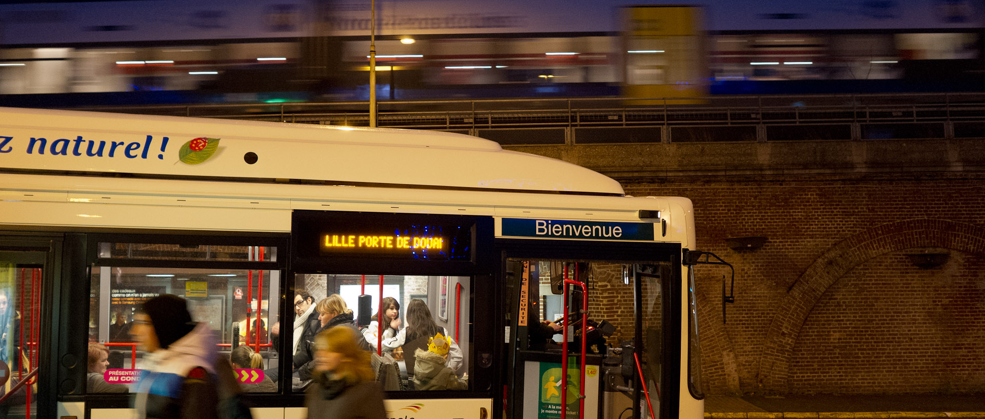 Autobus à l'arrêt Caulier, à Lille Fives, pendant le passage d'un train de banlieue.