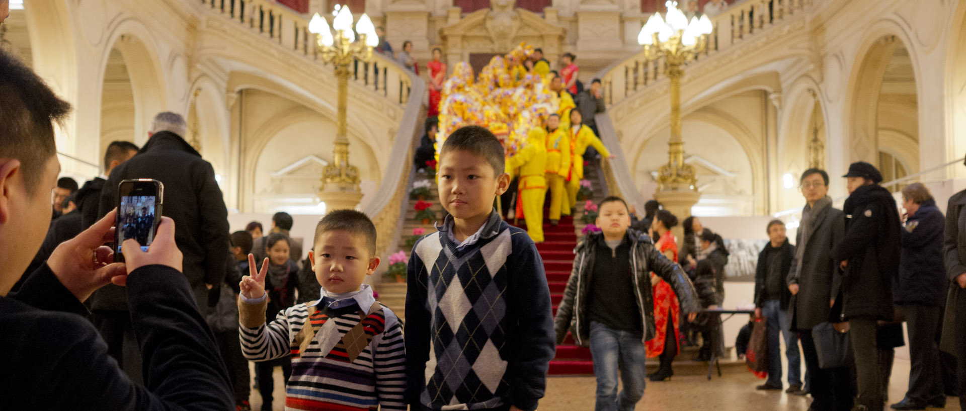 Enfants chinois se faisant photographier pendant la réception pour le nouvel an chinois, à la mairie du 10ème arrondissement, à Paris.