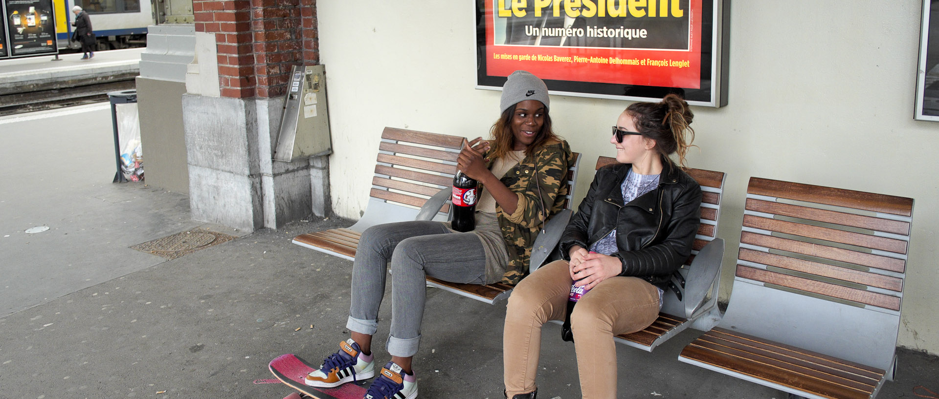Jeunes filles avec des skateboard, sur un banc, à la gare de Lille Flandres.