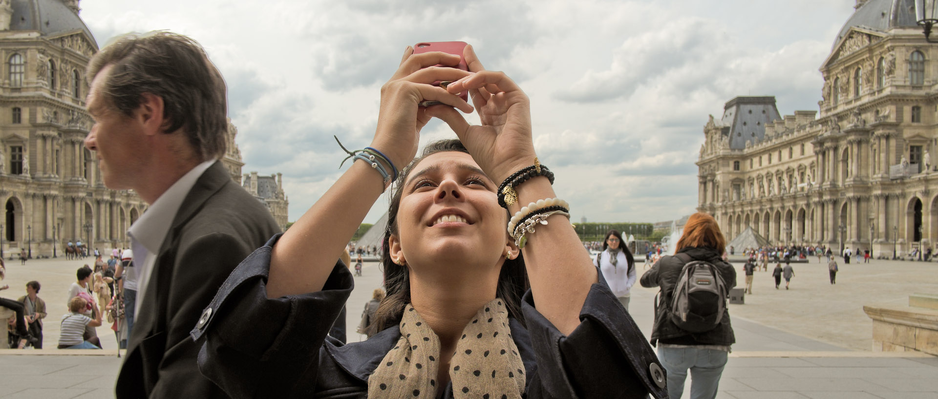 Touriste photographiant le musée du Louvre, à Paris.