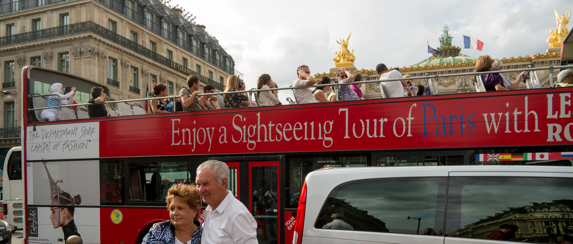Touristes dans un autobus à impériale, place de l'Opéra, à Paris.
