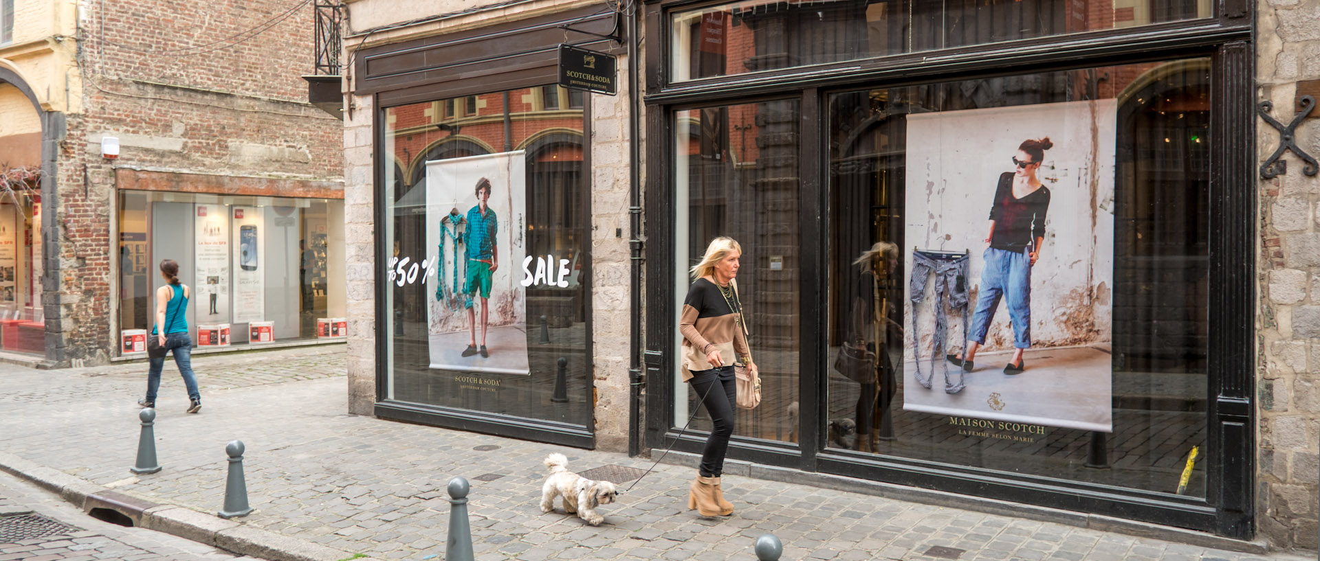 Femme avec son chien devant une boutique de mode, rue de la Monnaie, à Lille.