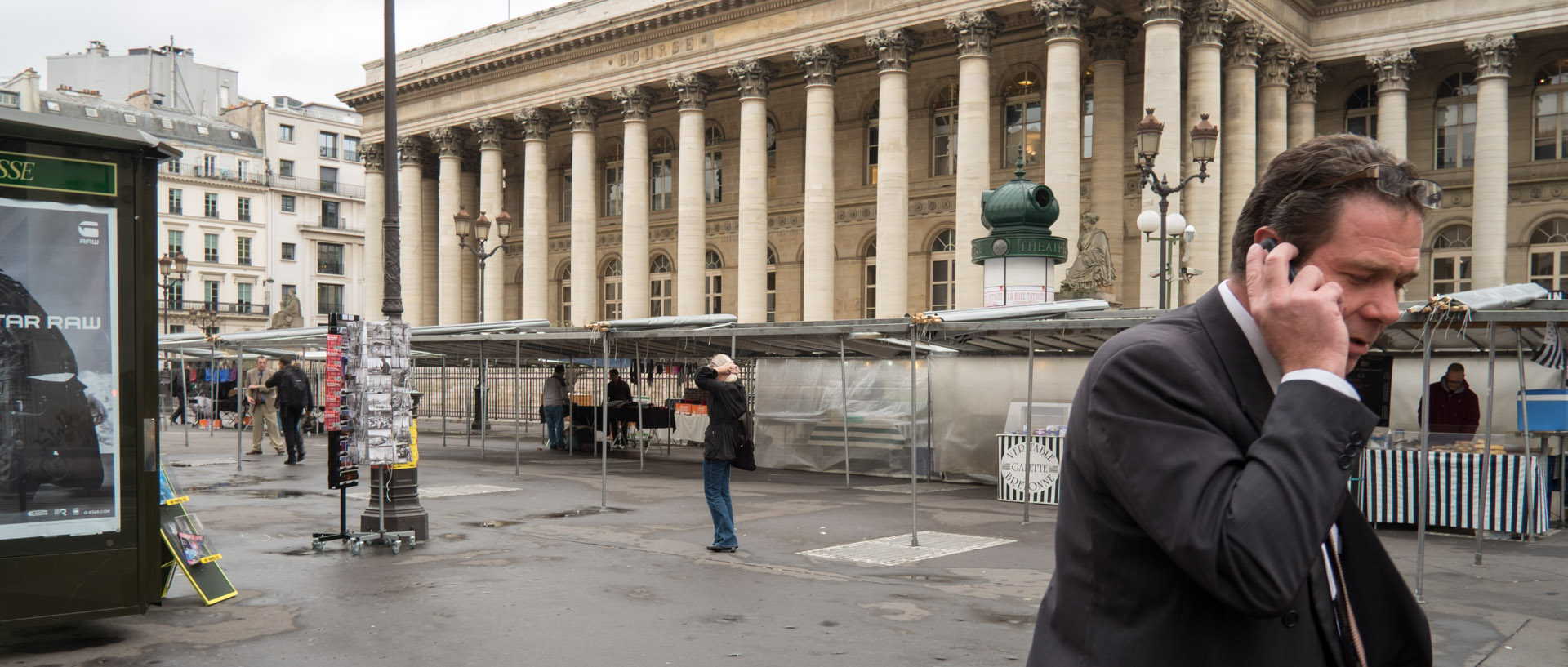 Homme avec son téléphone portable devant la bouse, à Paris.