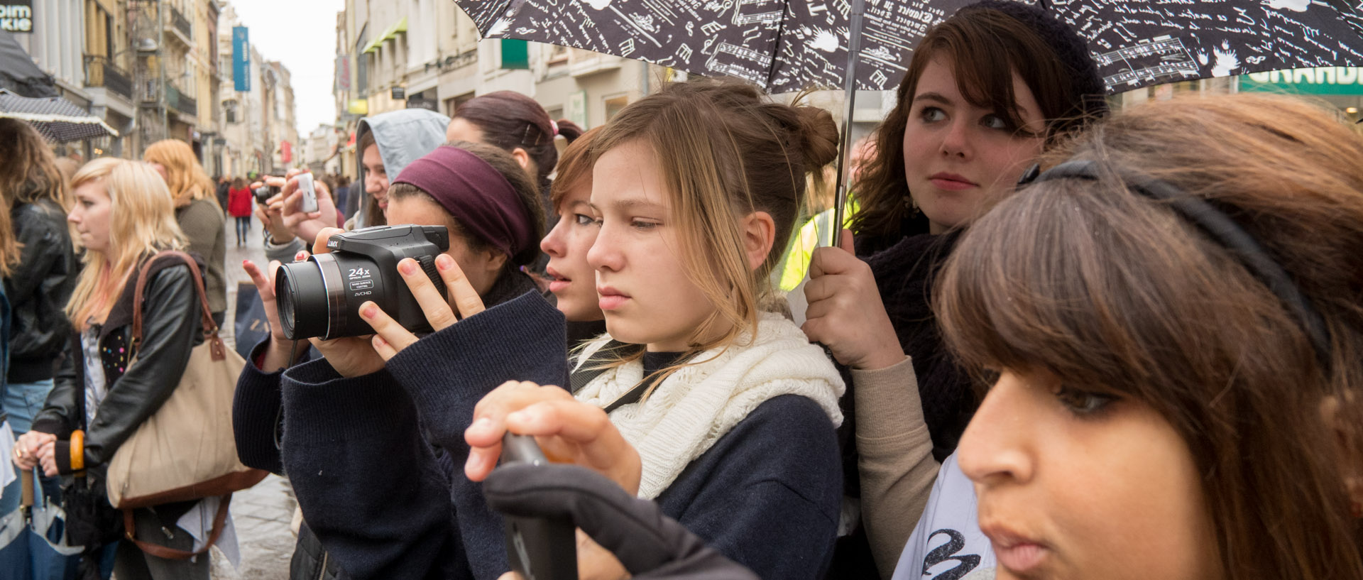 Jeune fille photographiant une démonstration de flashmob, rue de Béthune, à Lille.