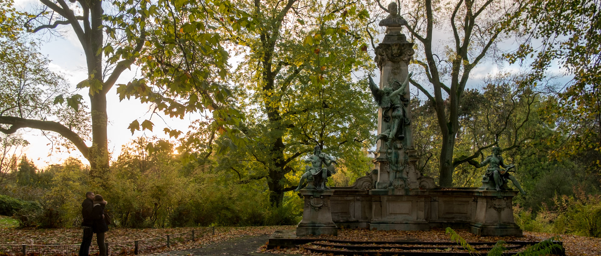 Couple d'amoureux devant un monument sculpté par Alphonse-Amédée Cordonnier à la mémoire de Gustave Nadaud, dans le parc Barbieux, à Roubaix.