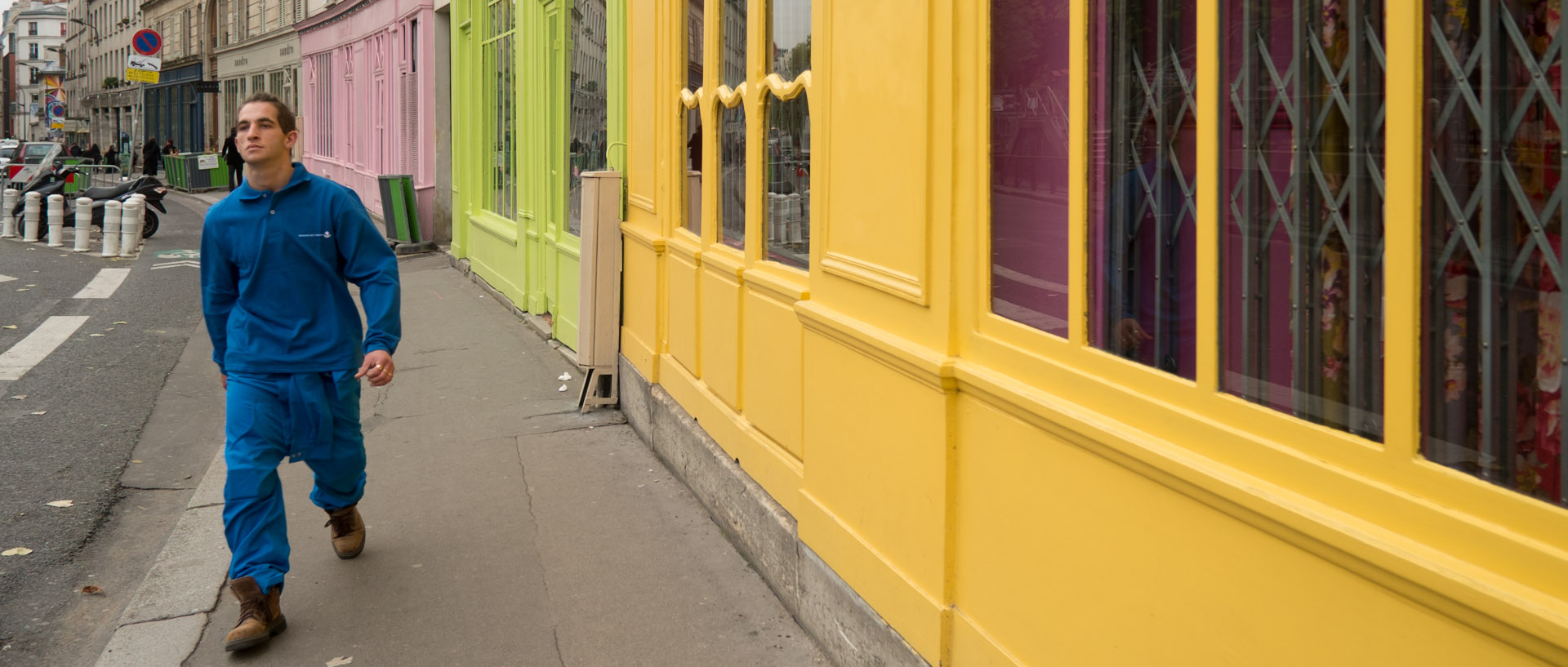 Homme en bleu devant boutique jaune, quai de Valmy, à Paris.