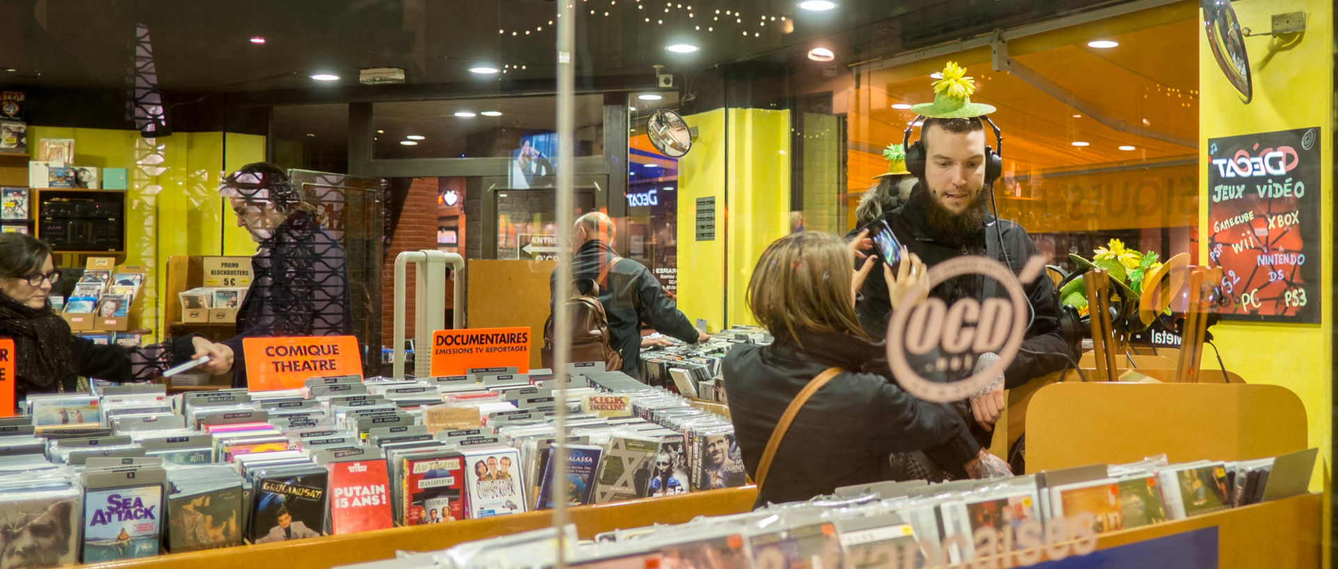 Jeune homme avec un casque audio dans un magasin de DVD et CD, rue de Tanneurs, à Lille.