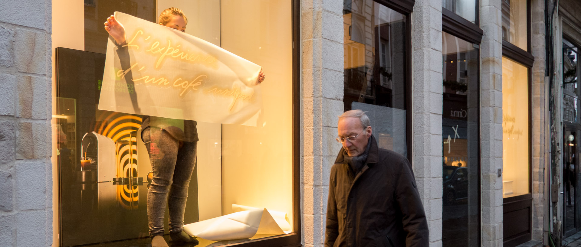 Décoration d'une vitrine Nespresso devant un passant impassible, rue Esquermoise, à Lille.