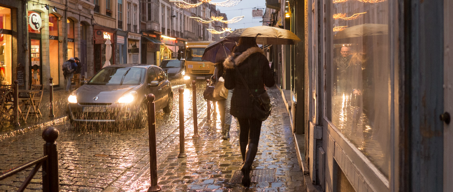 Femme sous un parapluie, rue Royale, à Lille.