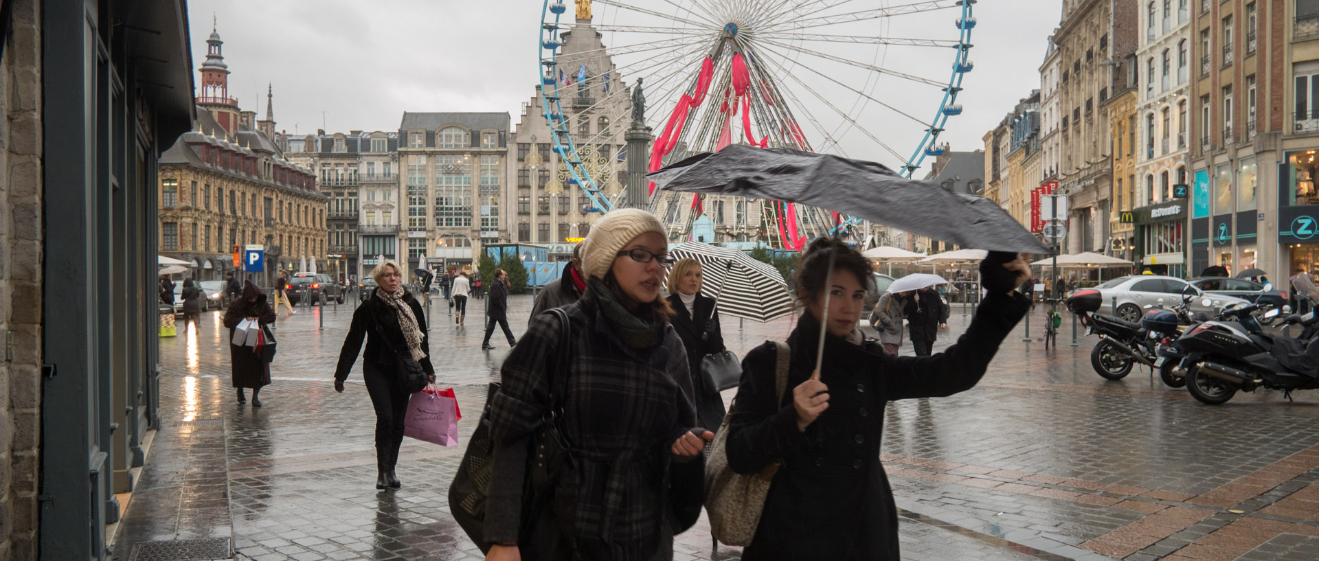 Passantes sous la pluie et dans le vent, place du Général-de-Gaulle, à Lille.