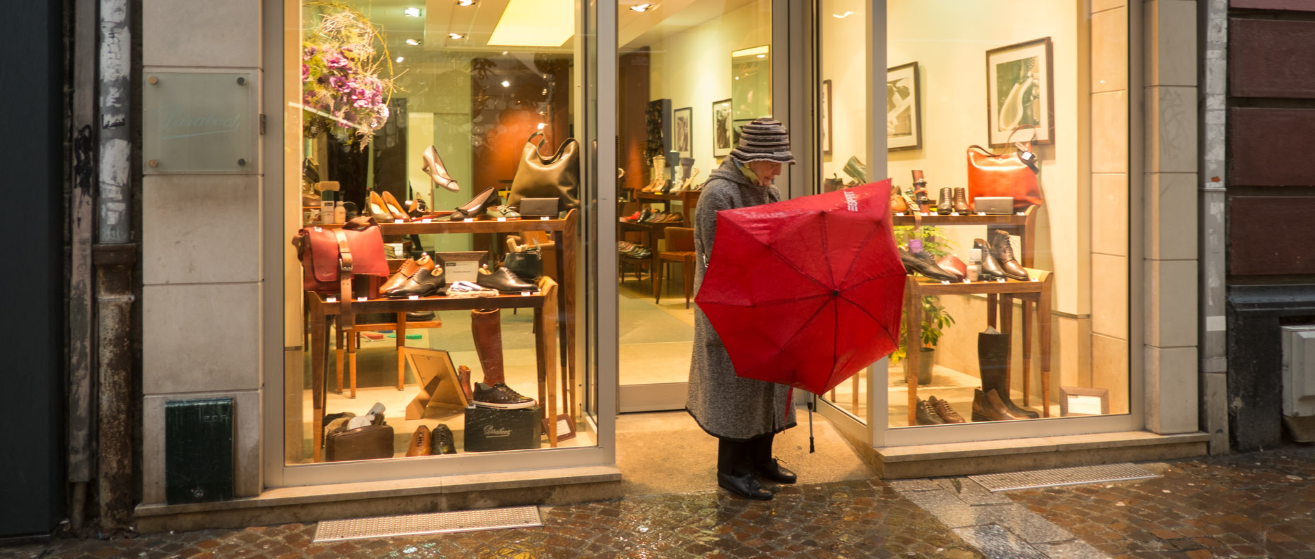 Vieille dame avec un parapluie brisé, rue de la Vieille Comédie, à Lille.