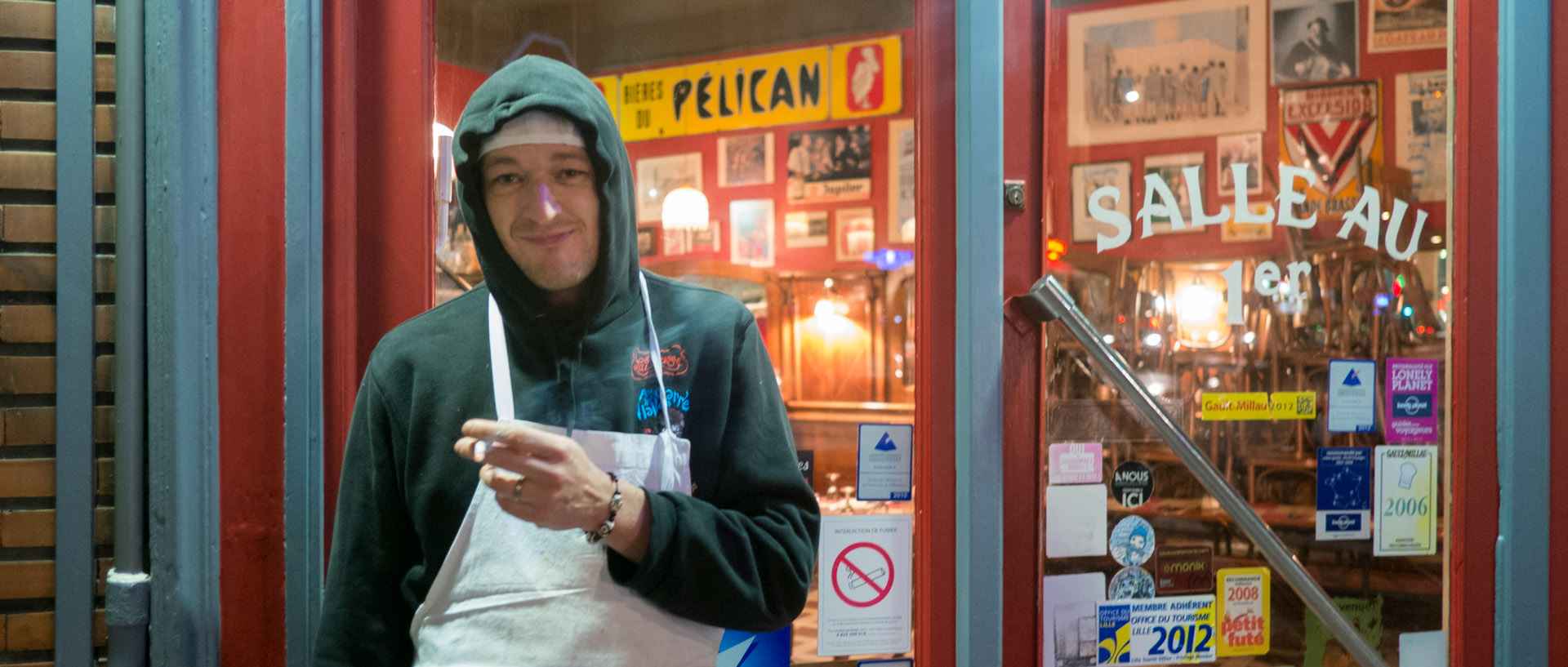 Cuisinier fumant une cigarette devant son restaurant, rue Solférino, à Lille.