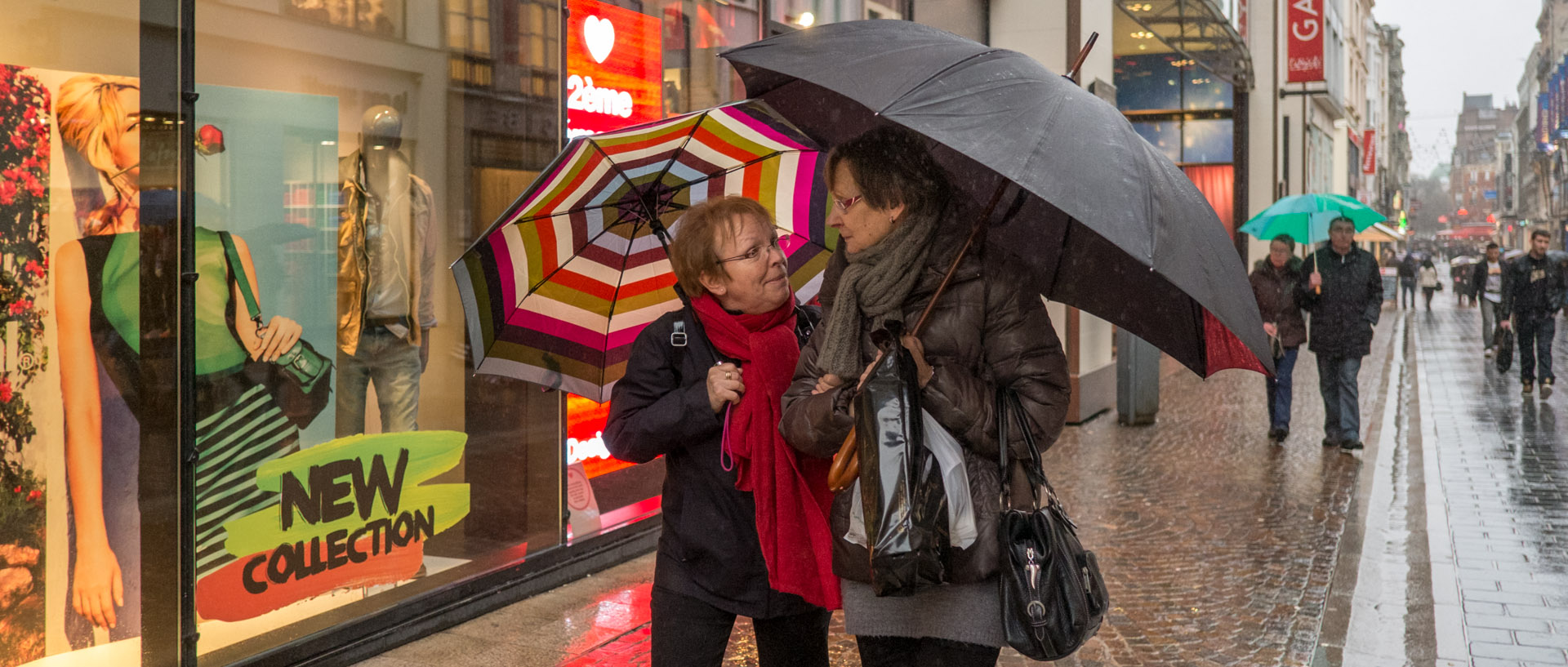 Femmes discutant sous la pluie, rue de Béthune, à Lille.