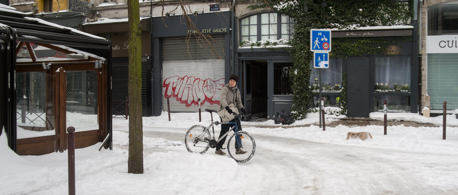 Cycliste marchant dans la neige, rue de la Clef, à Lille.