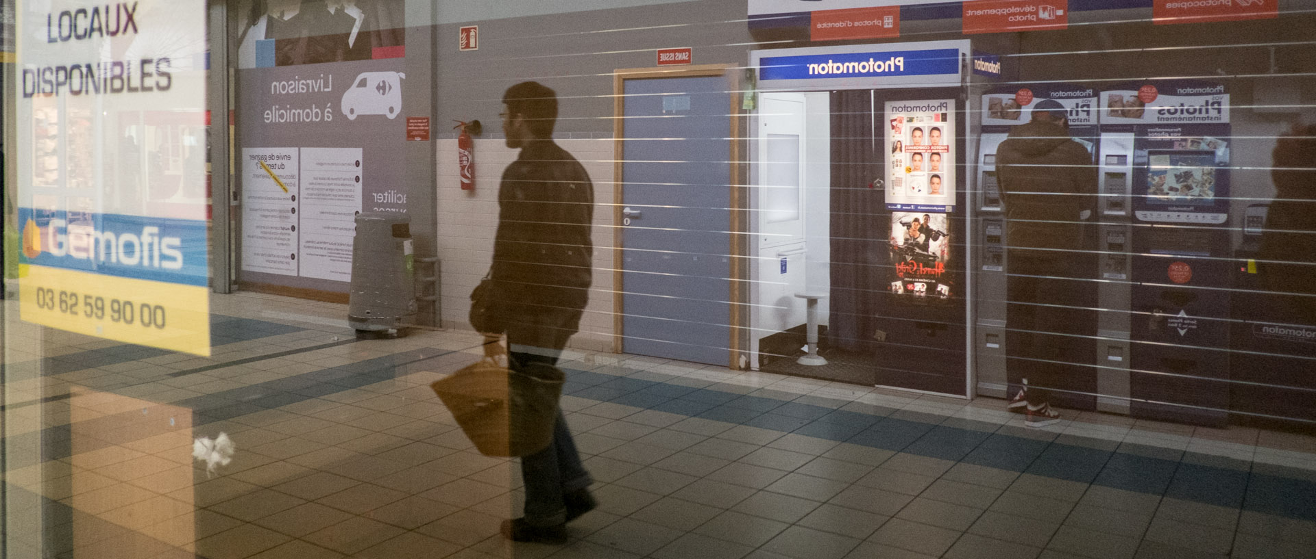 Homme marchant dans un centre commercial, rue Gambetta, à Wazemmes, Lille.