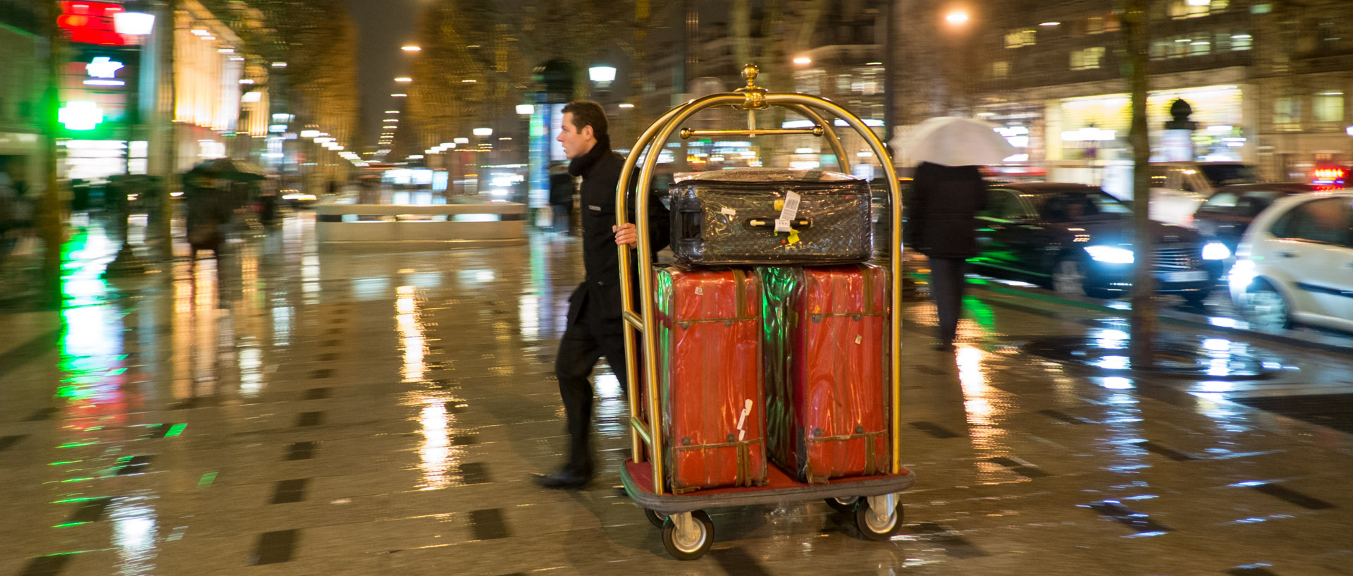 Bagagiste d'un grand hôtel sous une averse, avenue des Champs Elysées, à Paris.